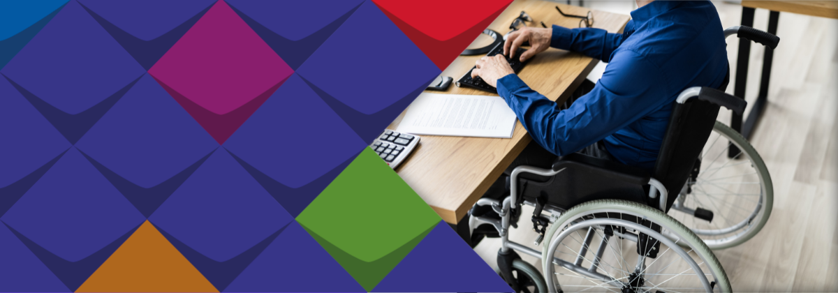 Eine Person im Rollstuhl am Schreibtisch: ein Symbolbild für einen Menschen, der an seinem Schreibtisch arbeitet. Er sitzt übrigens im Rollstuhl. Das Bild soll symblisch zeigen: Menschen mit Behinderungen wollen auf dem ersten Arbeitsmarkt arbeiten.